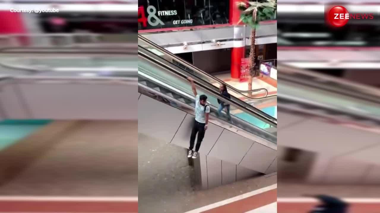 Viral Video: एस्केलेटर पर लटकते हुए युवक ने की ऐसी हरकत, देख भड़क उठे हुए लोग, वीडियो वायरल