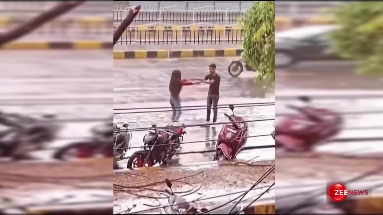 Viral Video: तेज बारिश में बीच सड़क पर नाचते दिखे लड़का-लड़की, पीछे से गुजरती गाड़ियों से बाहर झांक देखने लगे लोग
