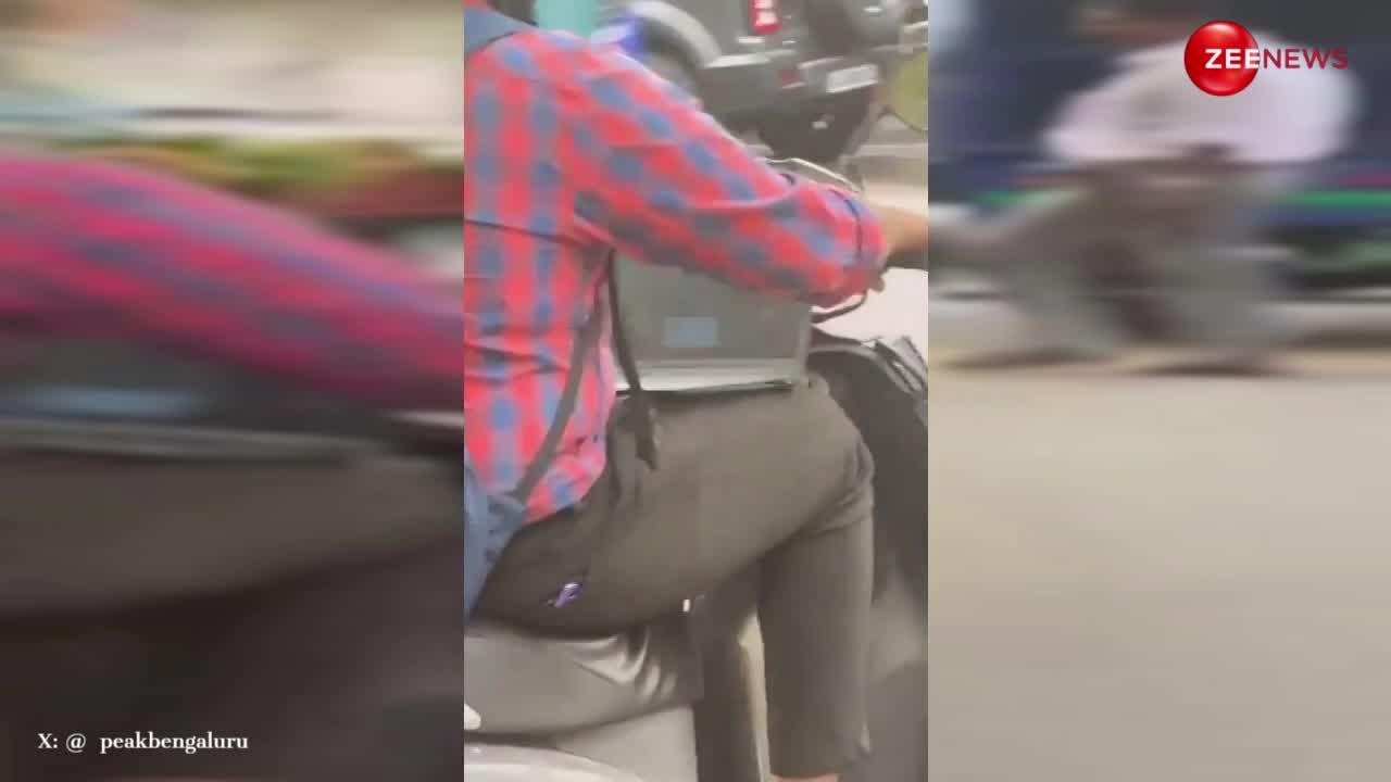 स्कूटर चलाते हुए गोद में लैपटॉप पर काम करता दिखा शख्स, लोग बोले- गजब जुगाड़ु हैं इंडियन
